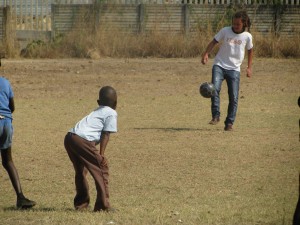 volunteer playing football with children 